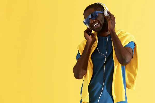 Moda. Hombre escuchando música en auriculares, retrato colorido — Foto de Stock