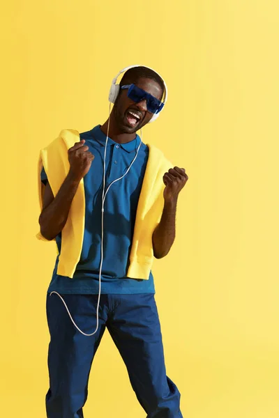 Hombre con auriculares escuchando música y cantando en retrato de estudio — Foto de Stock