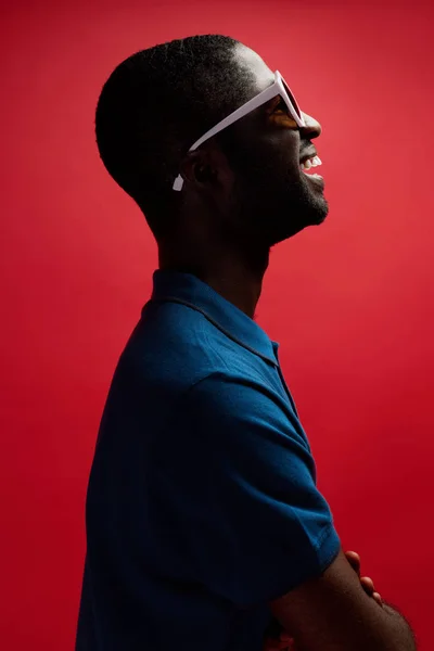 Fashion. Smiling black man in sunglasses on background profile