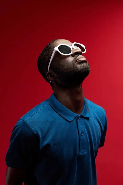 Retrato de hombre negro en gafas de sol sobre fondo rojo — Foto de Stock