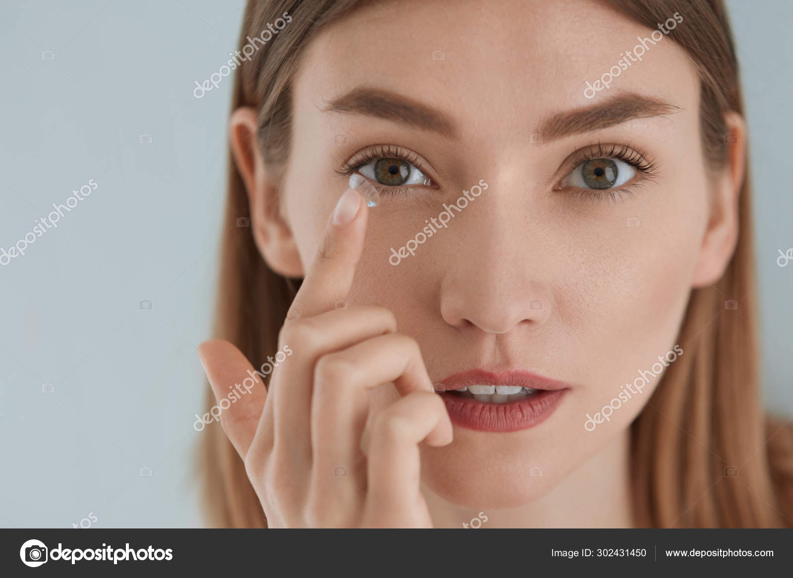 Contact eye lens. Woman applying eye contacts on eyes closeup Stock