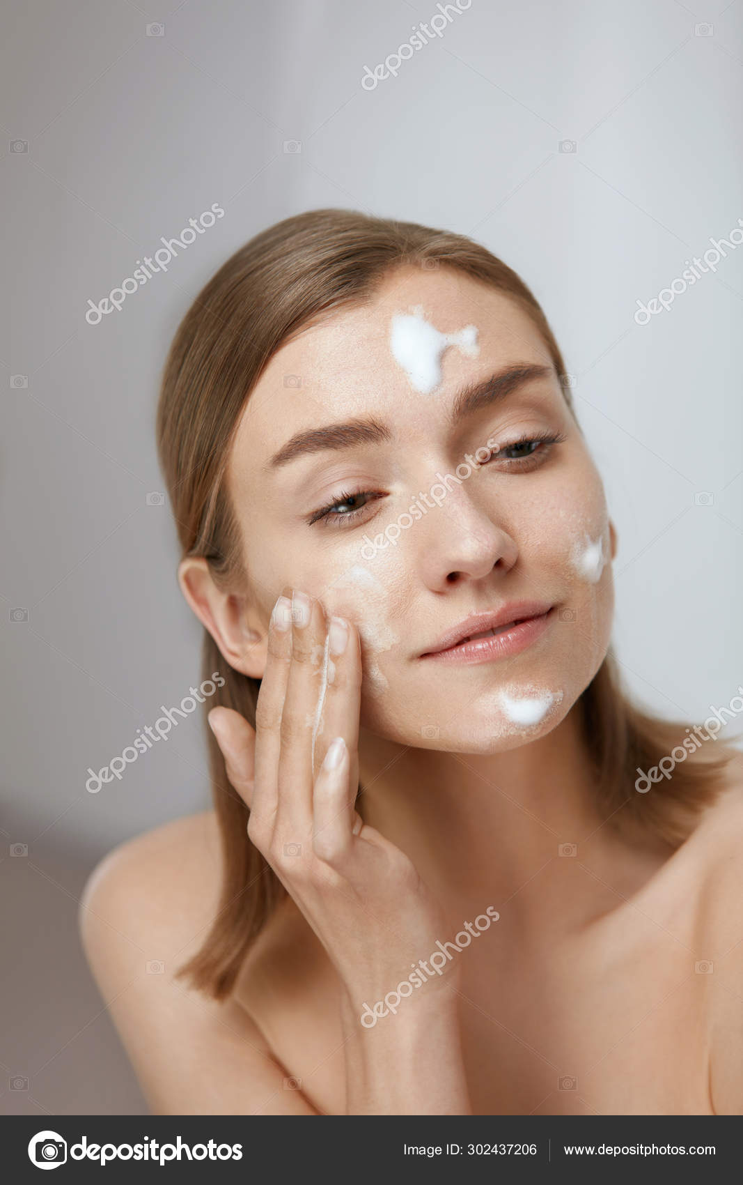 Soin visage. Femme appliquant un nettoyant facial sur le visage gros plan  image libre de droit par puhhha © #302437206