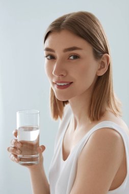 Woman with glass of fresh water in white portrait clipart
