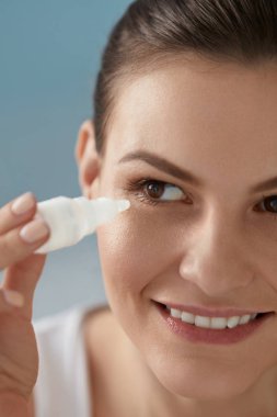 Göz damlası. Gözlerine yağlayıcı göz damlası uygulayan kadın