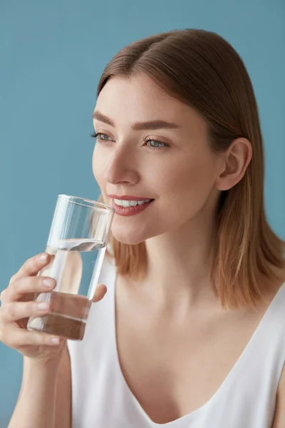 물을 마십니다. 유리 초상화에서 물을 마시는 미소 짓는 여자 — 스톡 사진