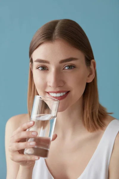 Minumlah air. Wanita tersenyum minum air dari potret kaca — Stok Foto