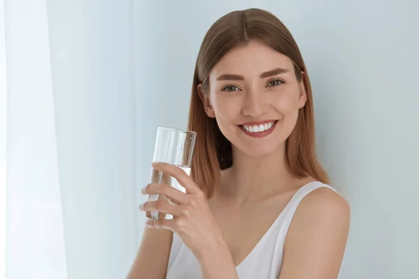 Kobieta ze szklanką słodkiej wody w białym portrecie — Zdjęcie stockowe