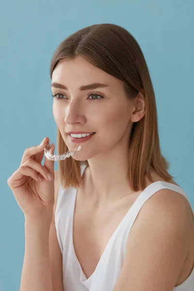 Отбеливание зубов. Женщина со здоровыми зубами с помощью съемных брекетов — стоковое фото