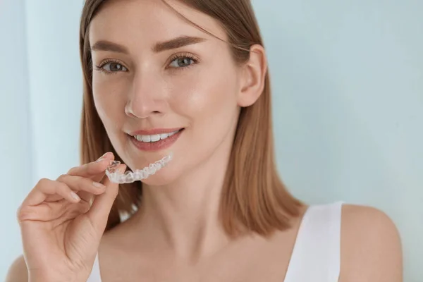 Dental care. Smiling woman using removable clear teeth brace — Stock Photo, Image