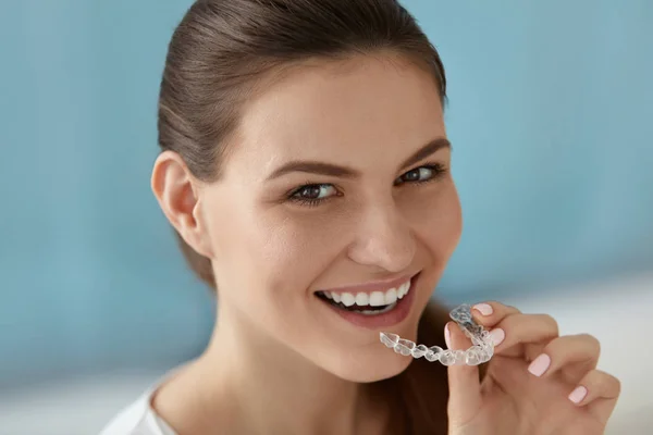 Dental care. Smiling woman using removable clear teeth braces — Stock Photo, Image