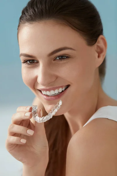 牙科护理。微笑的女人使用可移动的透明牙齿支架 — 图库照片