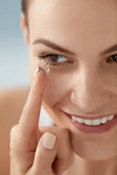 Contact eye lens. Smiling woman applying eye contacts closeup