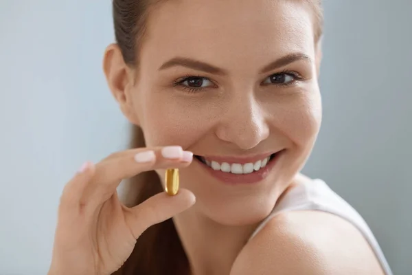 Vitamina. Mujer sonriente con omega 3 píldora, cápsula de aceite de pescado — Foto de Stock