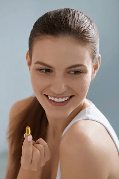 Vitamini. Omega 3 hapı ile gülümseyen kadın, balık yağı kapsülü — Stok fotoğraf