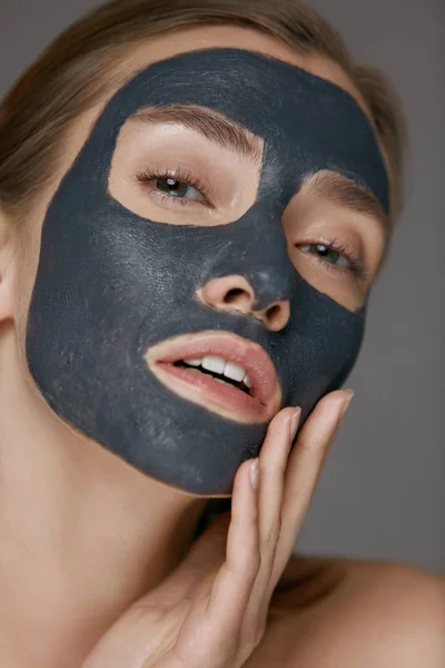 Skin care. Woman face with cosmetic spa clay mask closeup