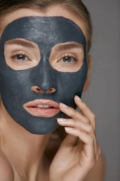 Skin care. Woman face with cosmetic spa clay mask closeup