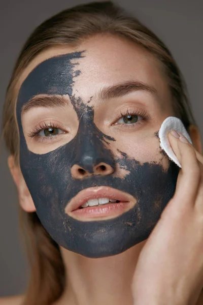 Tratamiento de belleza. Mujer quitándose la máscara con almohadilla blanca cosmética —  Fotos de Stock