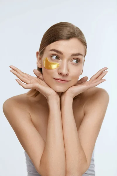 Parche ocular. Mujer con almohadillas de oro bajo los ojos en la cara de belleza —  Fotos de Stock