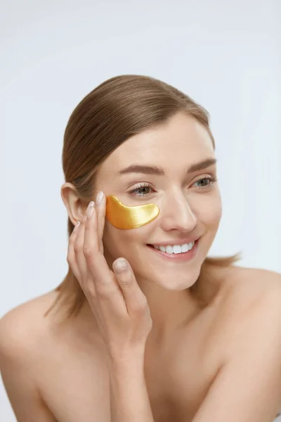 Bőrápolás. Nő arc alatt szem arany folt, szépség maszk — Stock Fotó