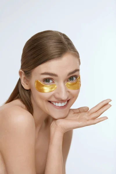 Perawatan kulit. Wanita dengan penutup mata emas, topeng kecantikan — Stok Foto