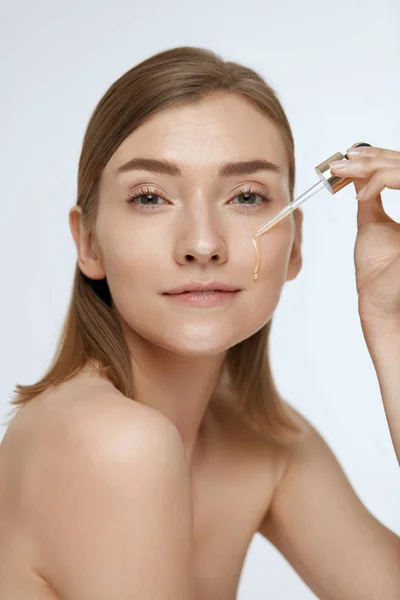Bőrápolás. Vérsavóolajat alkalmazó nő kozmetikai arcukon — Stock Fotó