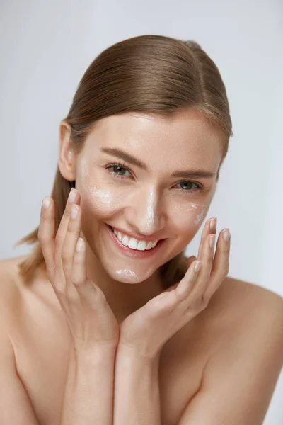 Cuidado de la piel. Mujer aplicando crema facial en belleza cara primer plano — Foto de Stock