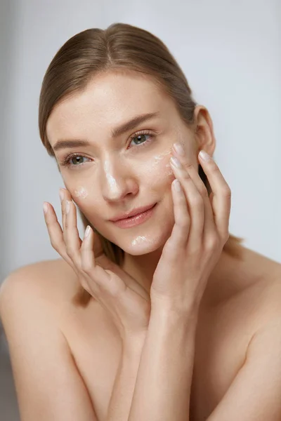 Cuidado de la piel. Mujer aplicando crema facial en belleza cara primer plano — Foto de Stock