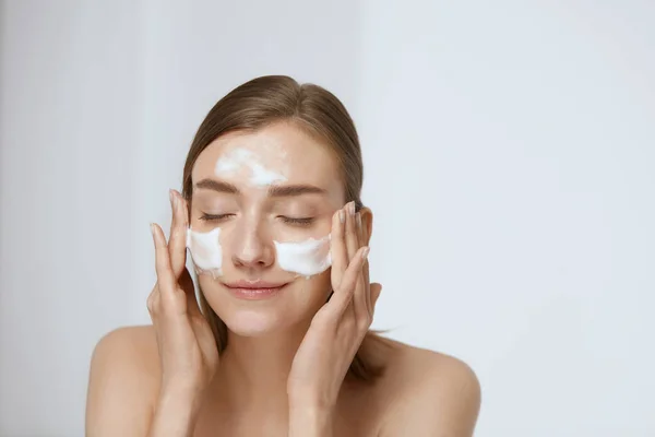 Pielęgnacja skóry twarzy. Kobieta stosujące środek do mycia twarzy na twarzy zbliżenie — Zdjęcie stockowe