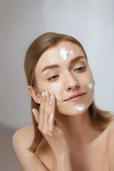 面部皮肤护理。妇女应用面部清洁剂在面部特写 — 图库照片
