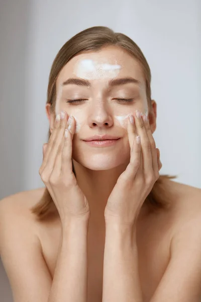 Perawatan wajah. Wanita membersihkan kulit wajah dengan sabun busa — Stok Foto