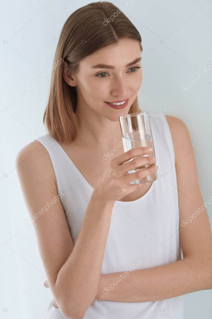 Drink. Woman drinking fresh pure water from glass portrait