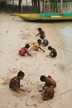 Balıkçı teknesi nin yakınındaki kum plajında oynayan zavallı çocuklar 