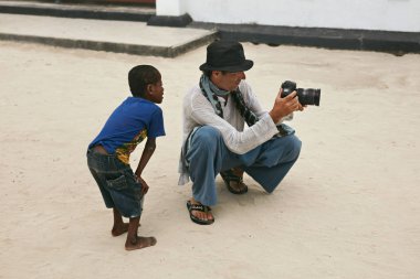 Turist fotoğrafçı kamera da yoksul çocuk çocuk fotoğrafları gösteren