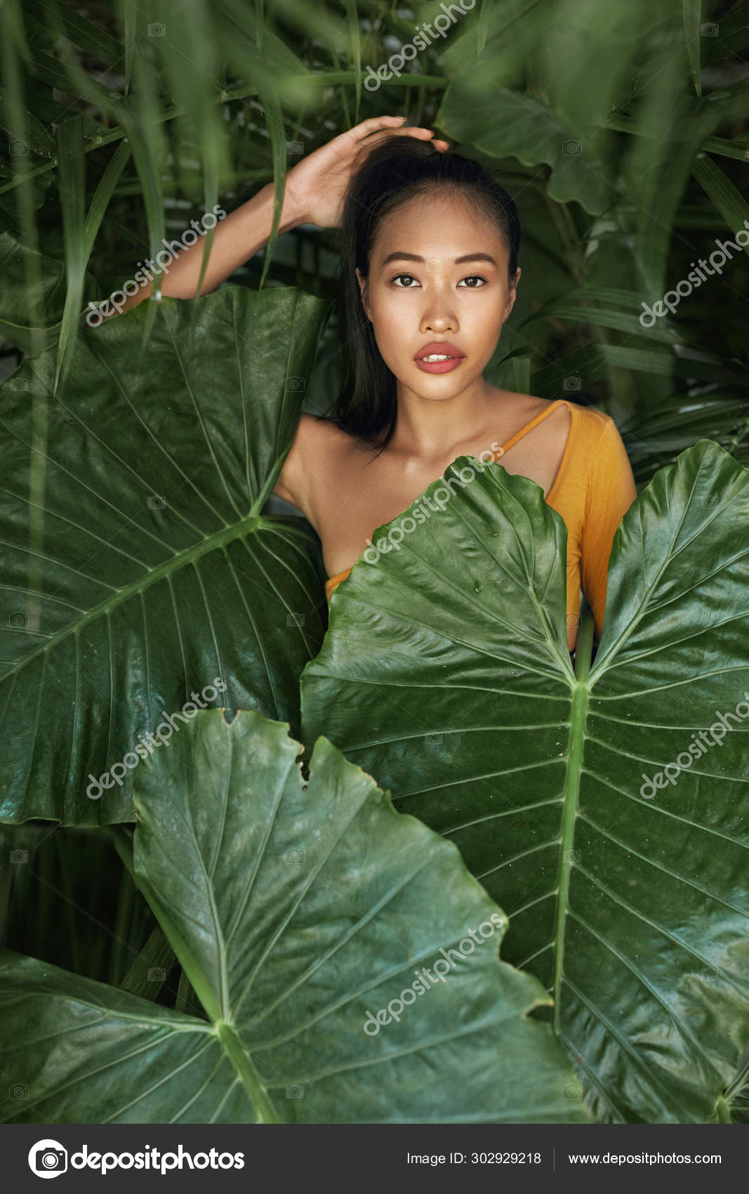Natural beauty. Woman with beautiful face behind tropical leaves Stock  Photo by ©puhhha 302929218