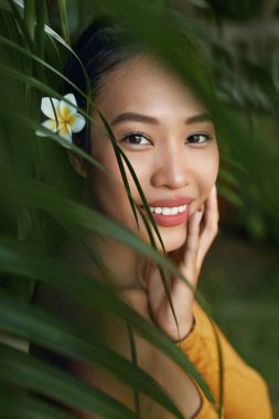 Güzel surat. Doğal makyajlı kadın, tropikal yapraklarda deri