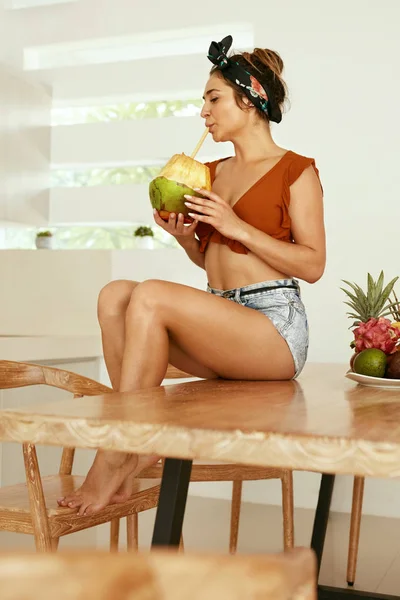 Bebida saludable. Mujer bebiendo agua de coco en la cocina — Foto de Stock