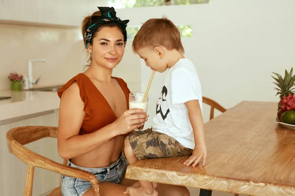 Dítě konzumní zdravé pití, veganské mléko s matkou v kuchyni — Stock fotografie