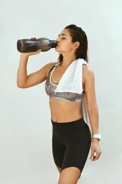 Mujer con ropa deportiva bebiendo agua después del entrenamiento — Foto de Stock