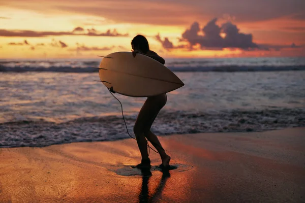 Sommer. Surfer Mädchen Silhouette mit Surfbrett am Sonnenuntergang Strand — Stockfoto