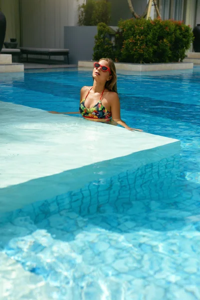 Nyáron. Nő a napszemüveg a medencében nyaralni — Stock Fotó