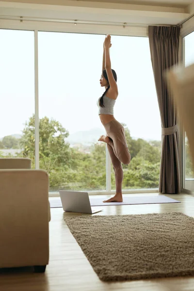 Girl practices yoga in tree pose, exercising at home in morning — Stock Photo, Image