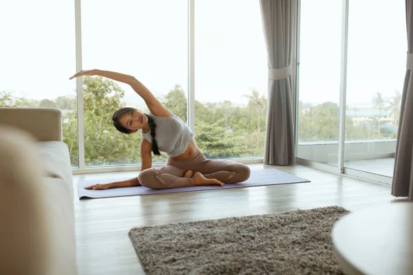 Yoga stretch. Girl practices yoga pose, stretching body at home — Stock Photo, Image