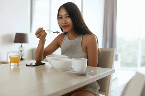 Mulher tomando café da manhã saudável em casa de manhã à mesa — Fotografia de Stock