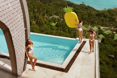 Yaz tatili. Sonsuzluk havuzuyakınında eğlenen mayolu kızlar