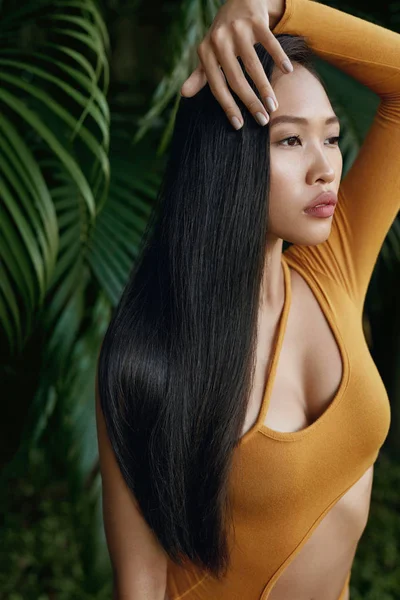 Belleza de pelo largo. Mujer con cabello liso en la naturaleza tropical —  Fotos de Stock