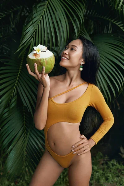 Chica de verano en traje de baño con bebida de coco en la naturaleza tropical — Foto de Stock
