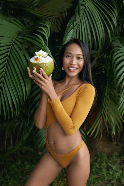 Chica de verano en traje de baño con bebida de coco en la naturaleza tropical — Foto de Stock
