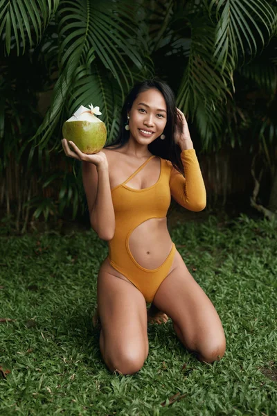Moda de verano. Chica en traje de baño con bebida de coco en la naturaleza — Foto de Stock