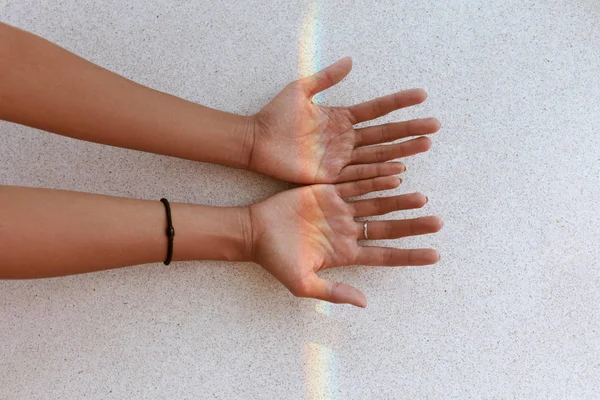 Arco iris en las manos. Mano femenina con pequeña luz de arco iris en las palmas — Foto de Stock
