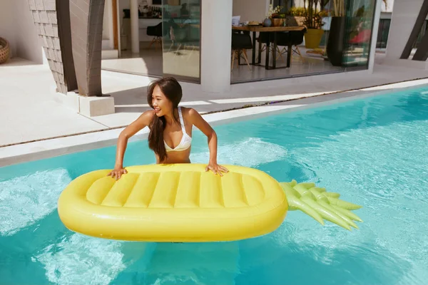 Vacaciones de verano. Mujer en traje de baño con flotador en la piscina — Foto de Stock